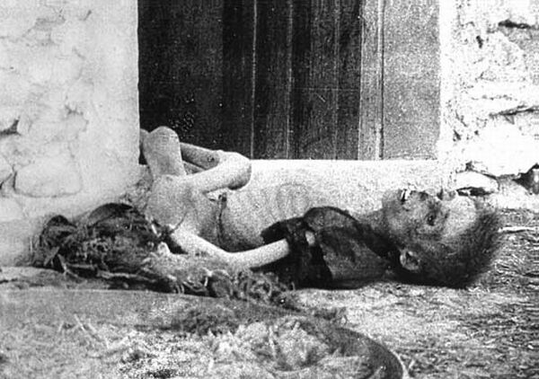 A Christian child lies dead in front of a house.