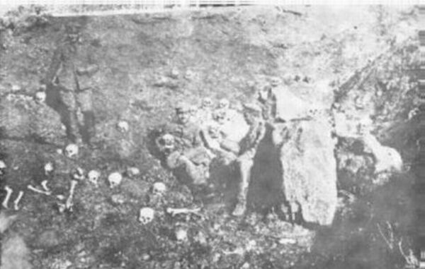 Soldiers pose next to bones of massacred Christians.