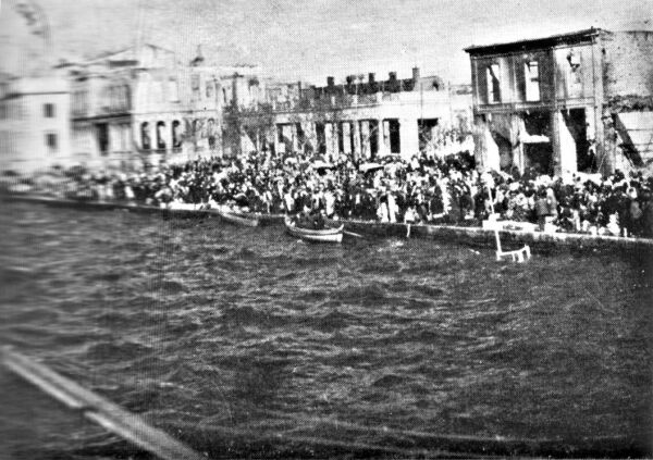 The same boat, completely sunken. Only a part of its mast is visible, on the right.